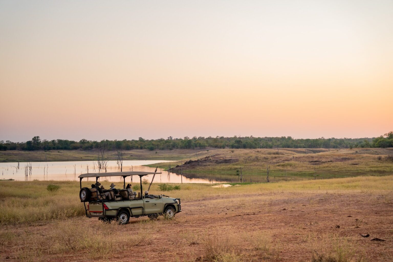 Véhicule de safari au coucher du soleil dans la savane zambienne